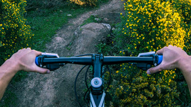 Joven practicando ciclismo. Dale a tu cuerpo una explosión de energía con XS bebida energizante de Amway.